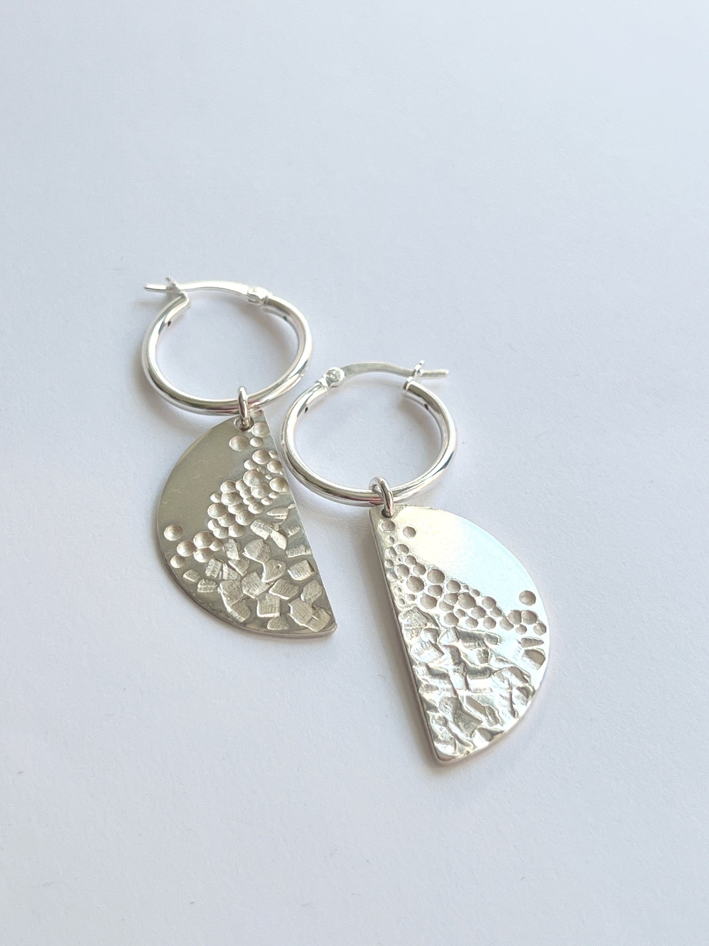 half-moon dangle hoops on a white background