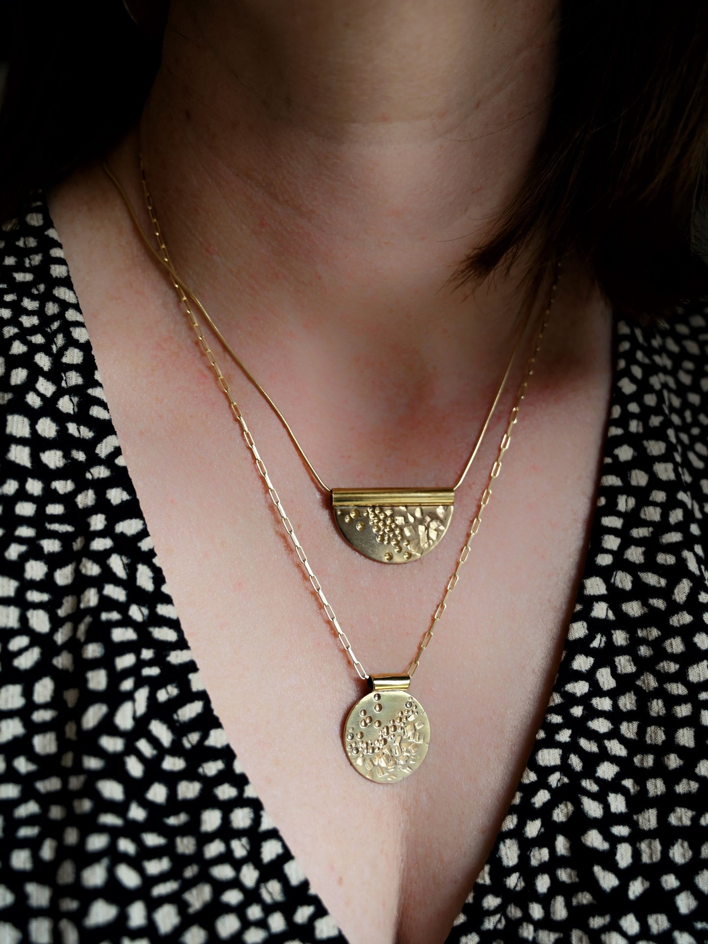 Contrast tube bronze pendant hanging around neck together with contrast disc pendant