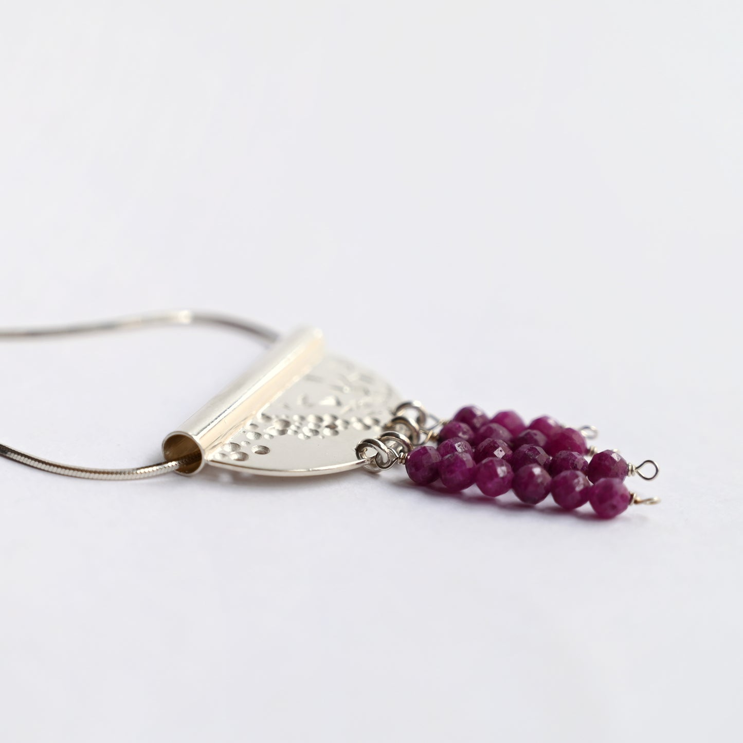 Contrast tube necklace with ruby detailed side view on white background