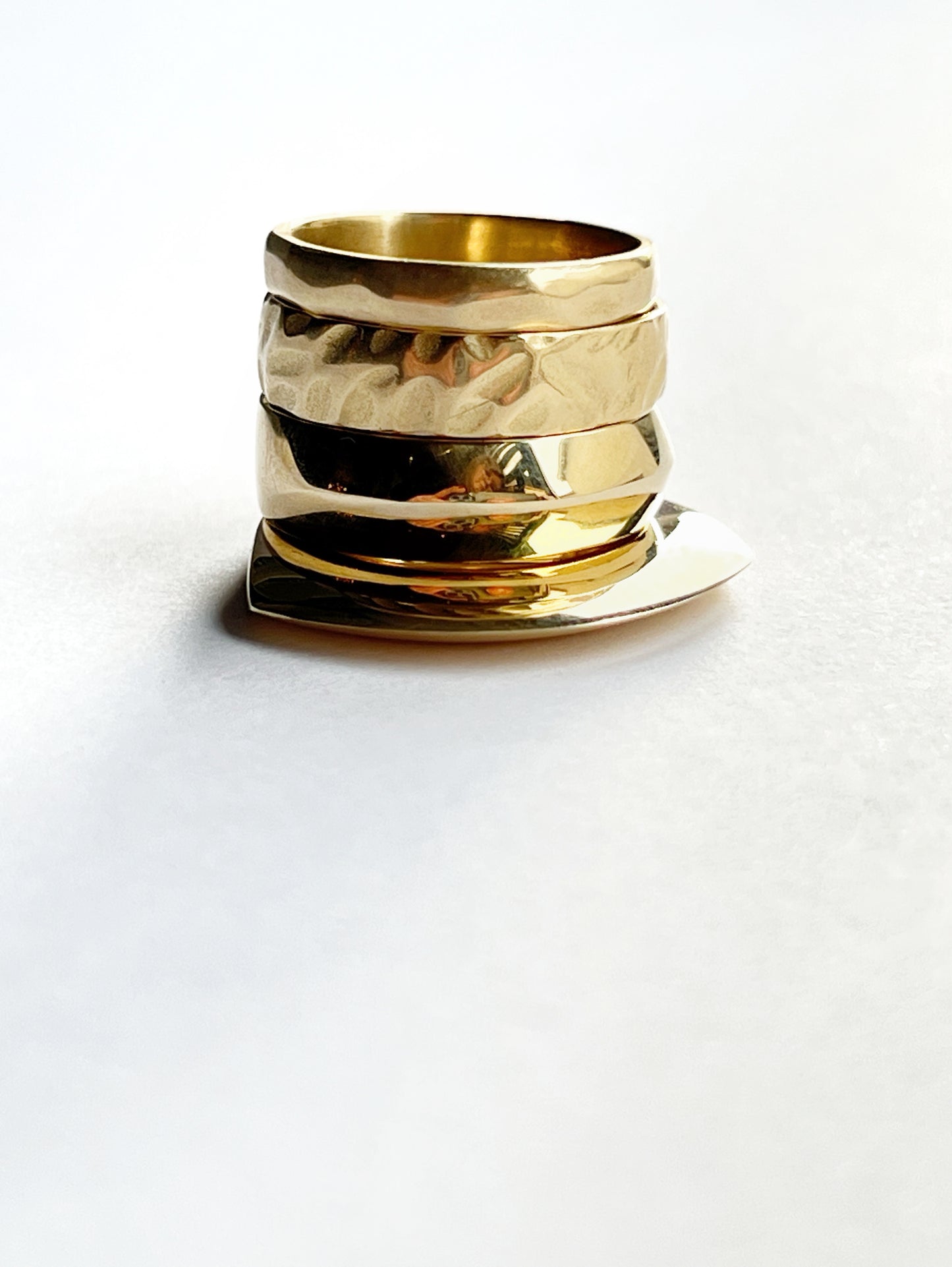 4 bronze rings stacked on top of each other close up with a white background