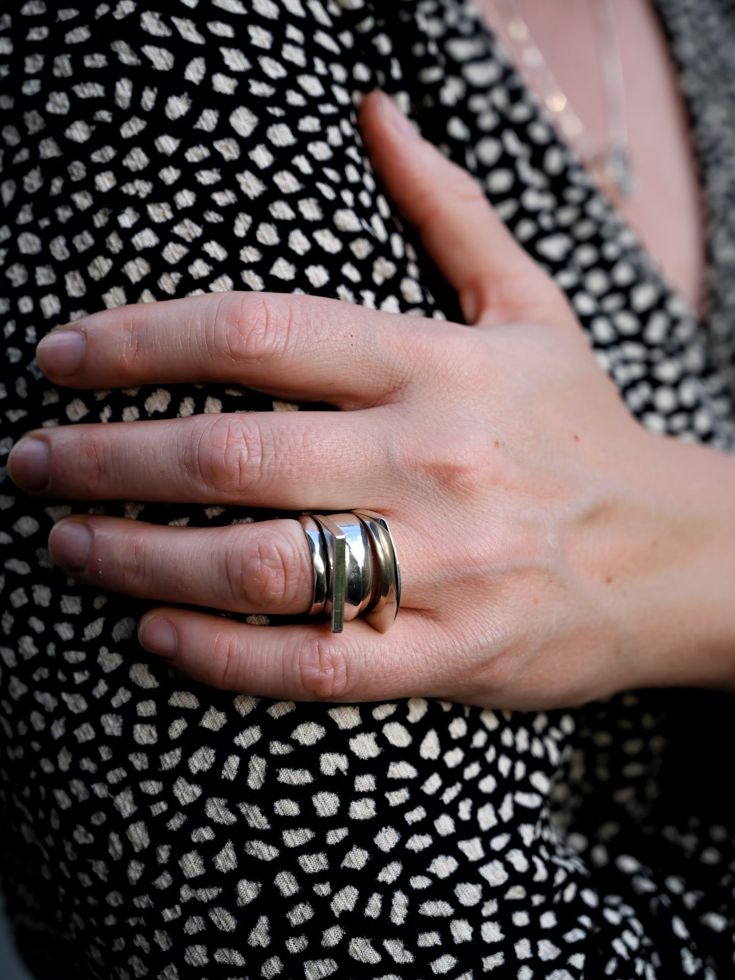 Silver stacking set with component ring, model's hand resting on her arm with black and white dots blouse in background