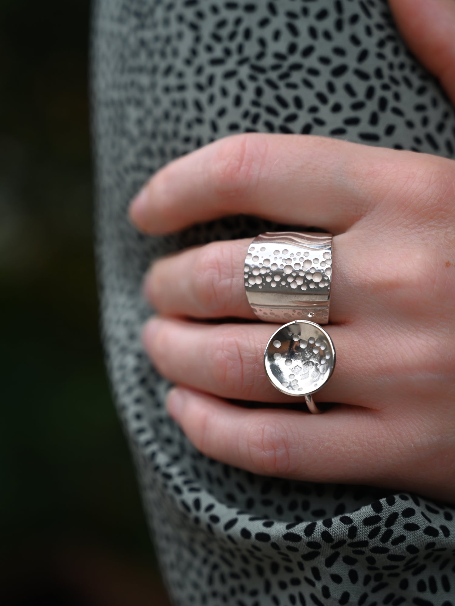 Close up view of parti ring on model hand paired with domed disc ring
