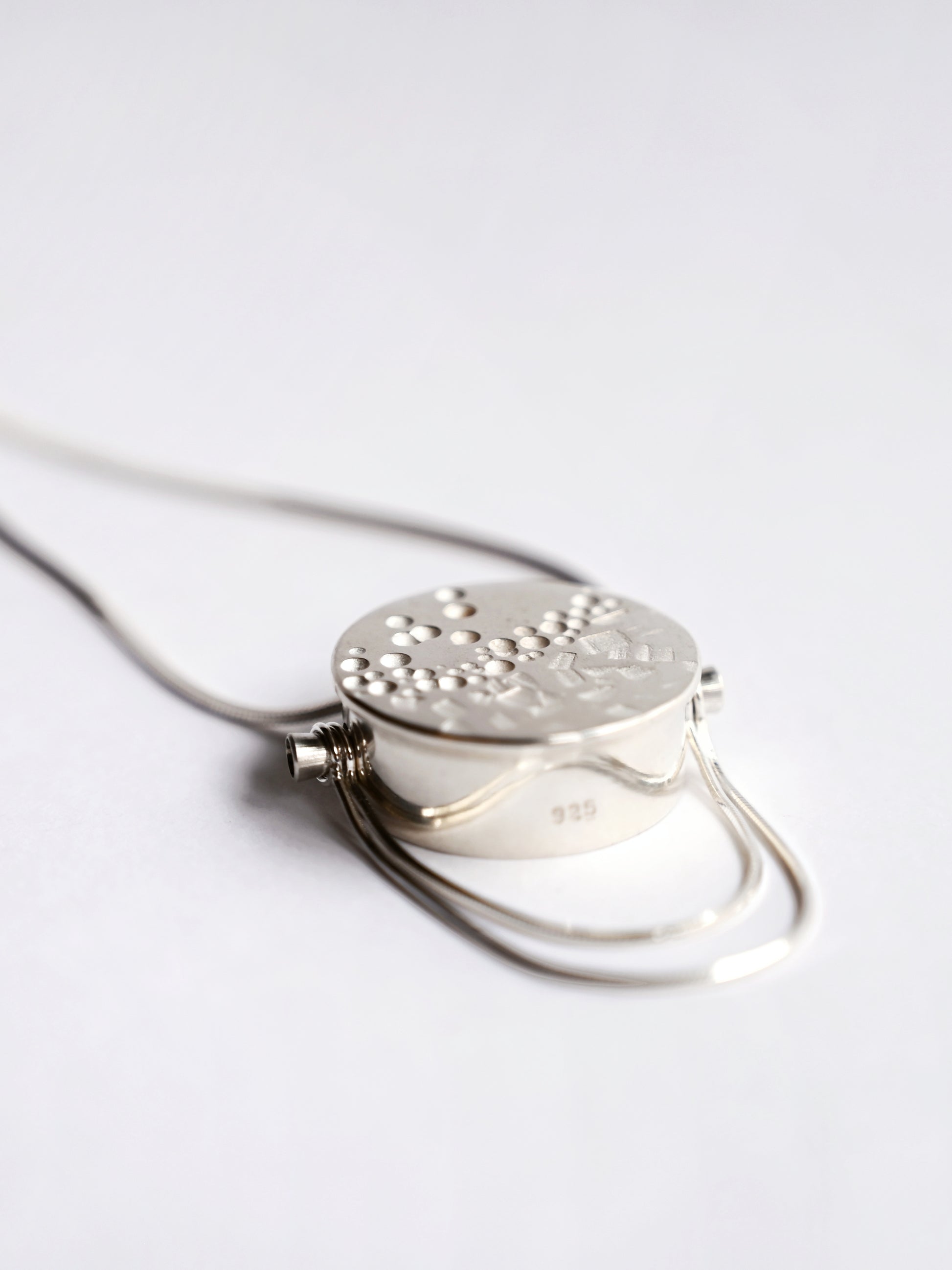 Silver large box pendant with snake chain detail on white background