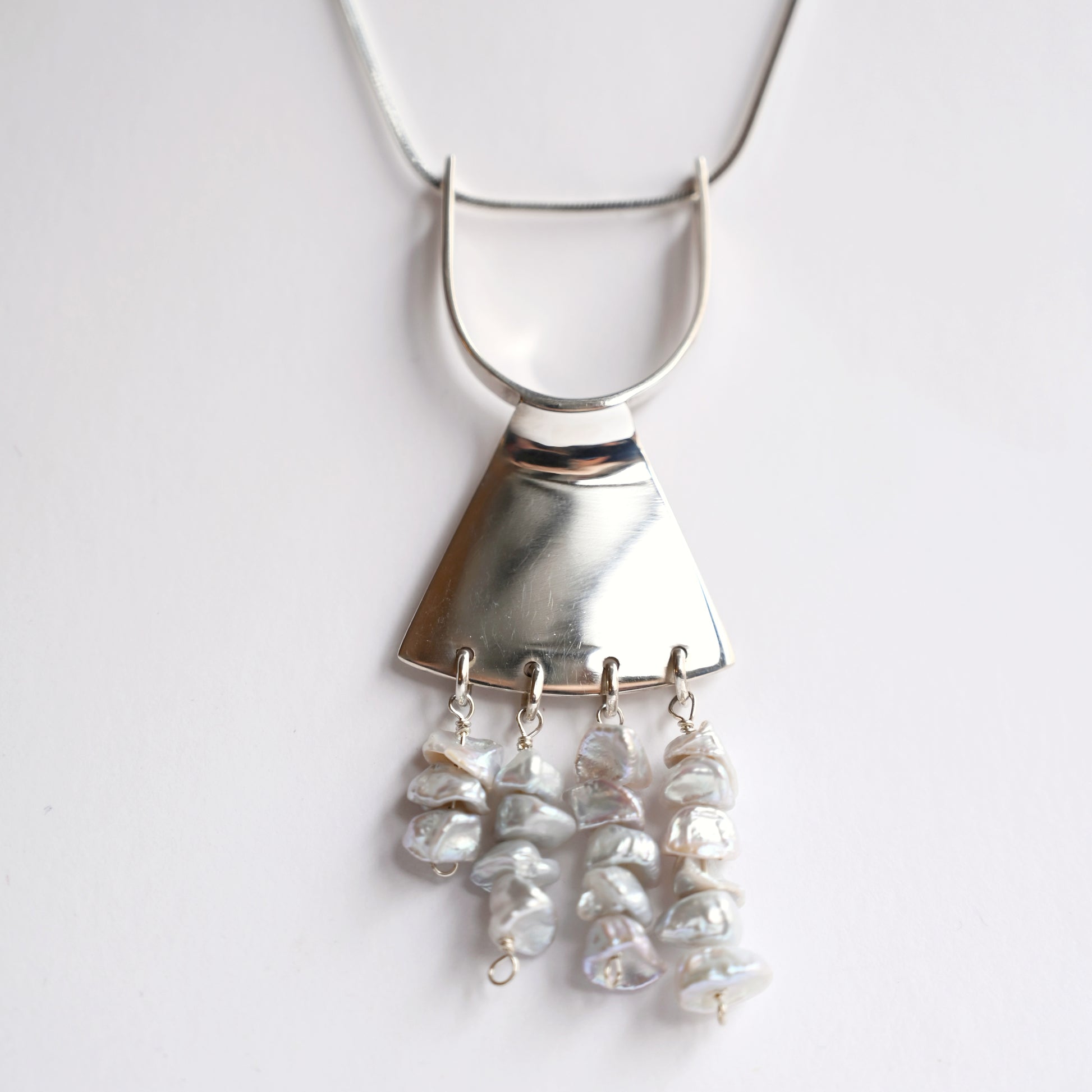 Art deco pendant in silver with pearls from front on white background
