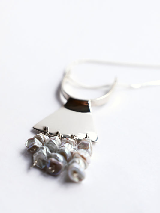 Art deco pendant in sterling silver with strings of freshwater pearls on white background
