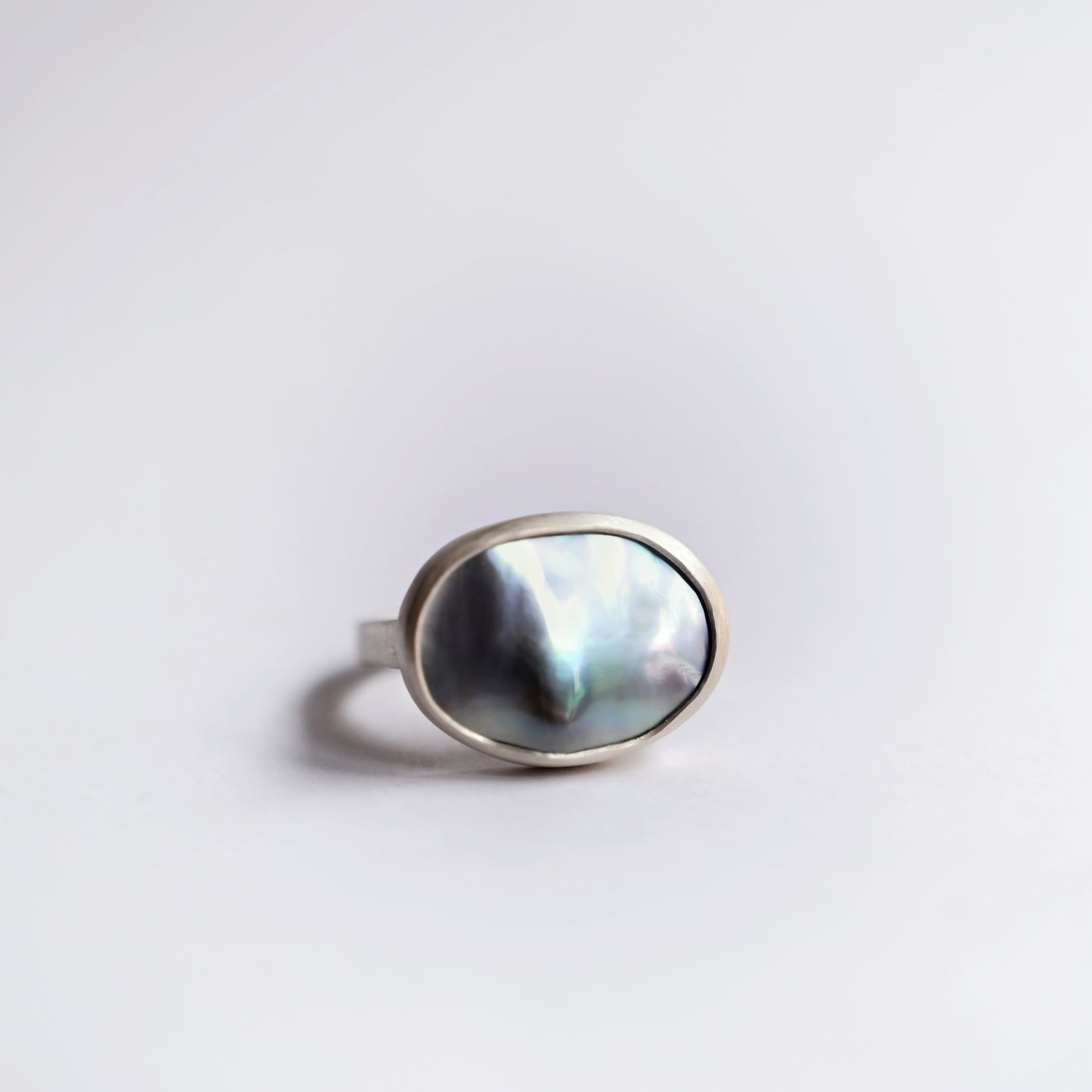 Direct front view of silver component ring with mabe pearl 1 on white background