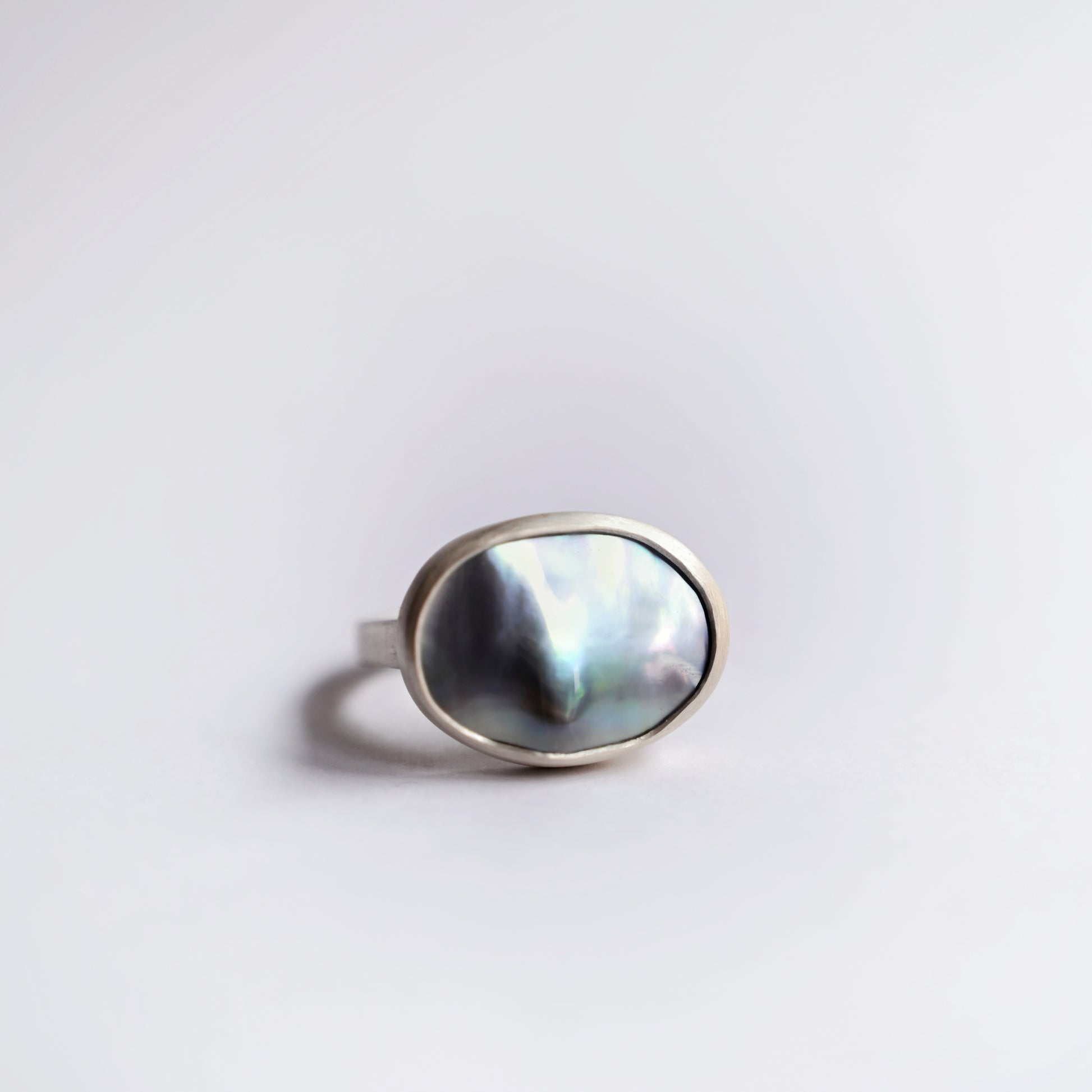 Direct front view of silver component ring with mabe pearl 1 on white background