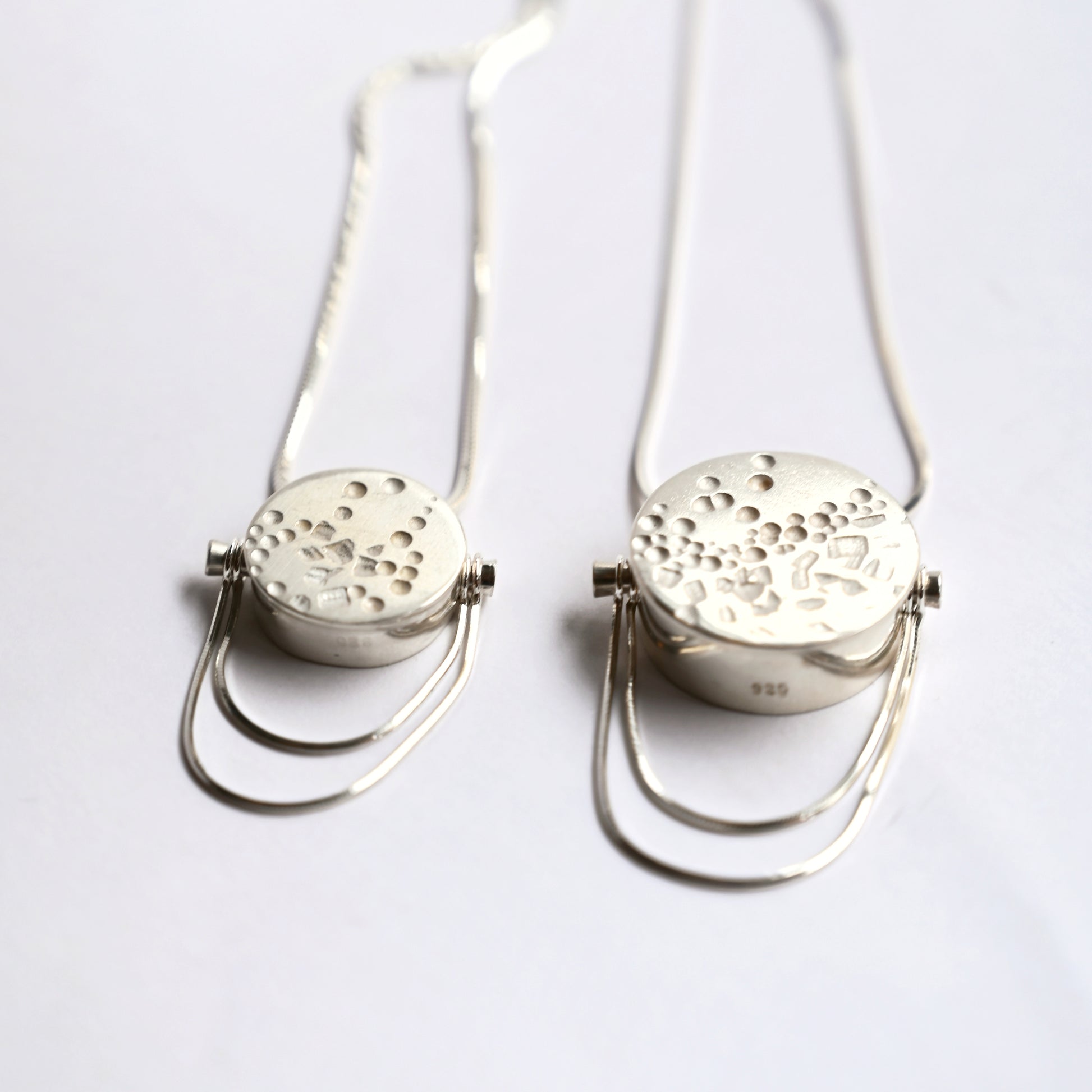 Silver box pendants with snake chain, top view on white background