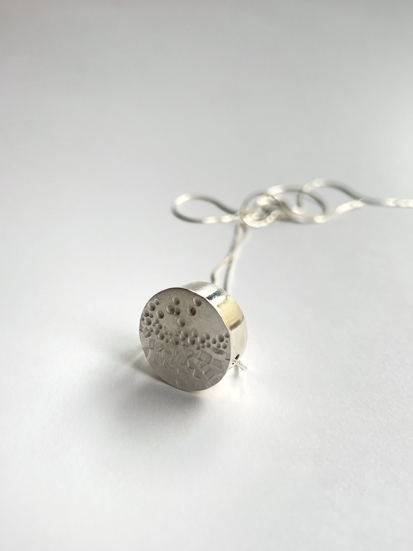 circle small necklace standing upright with a white background