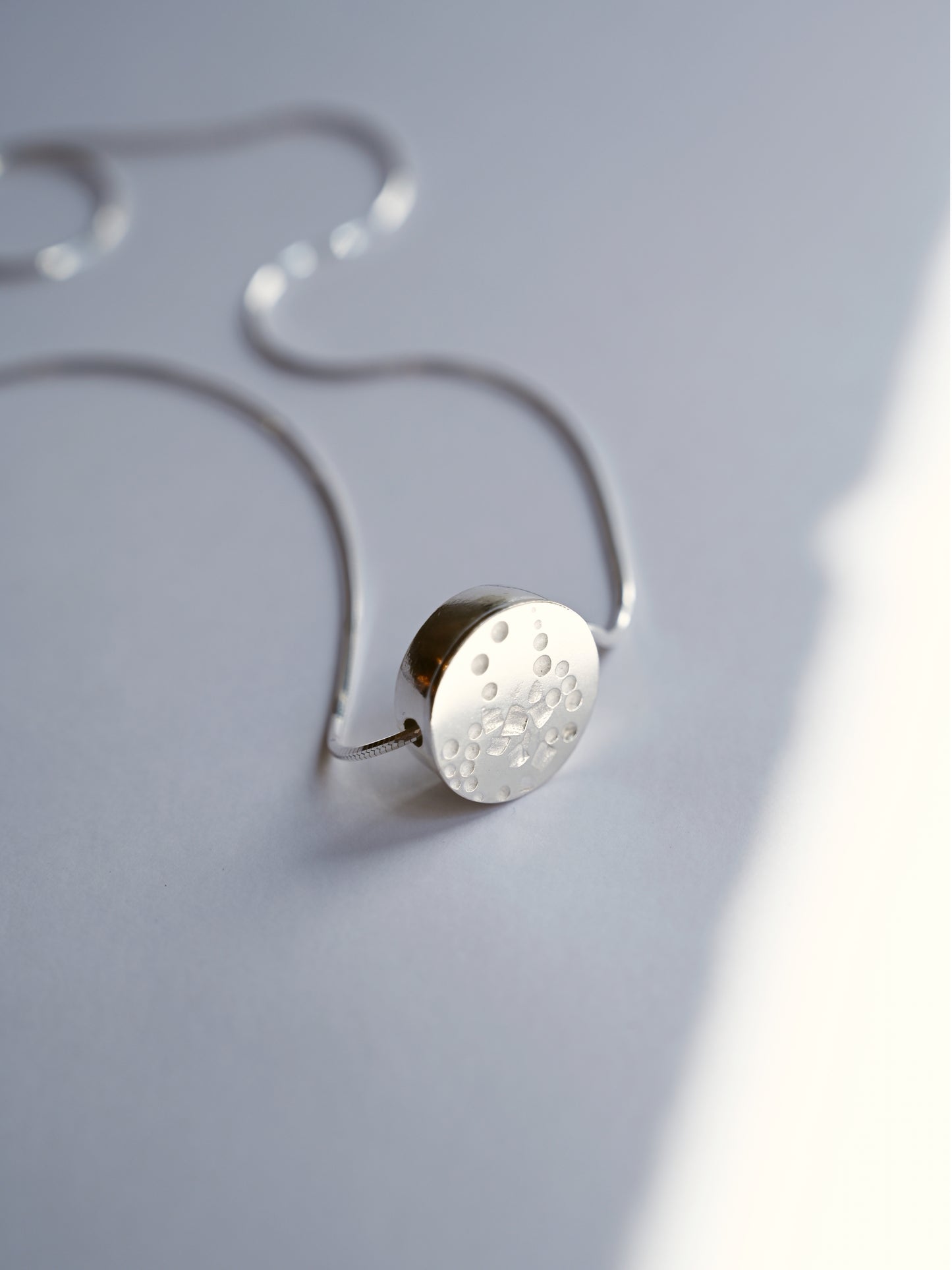 circle small necklace standing upright with a white background