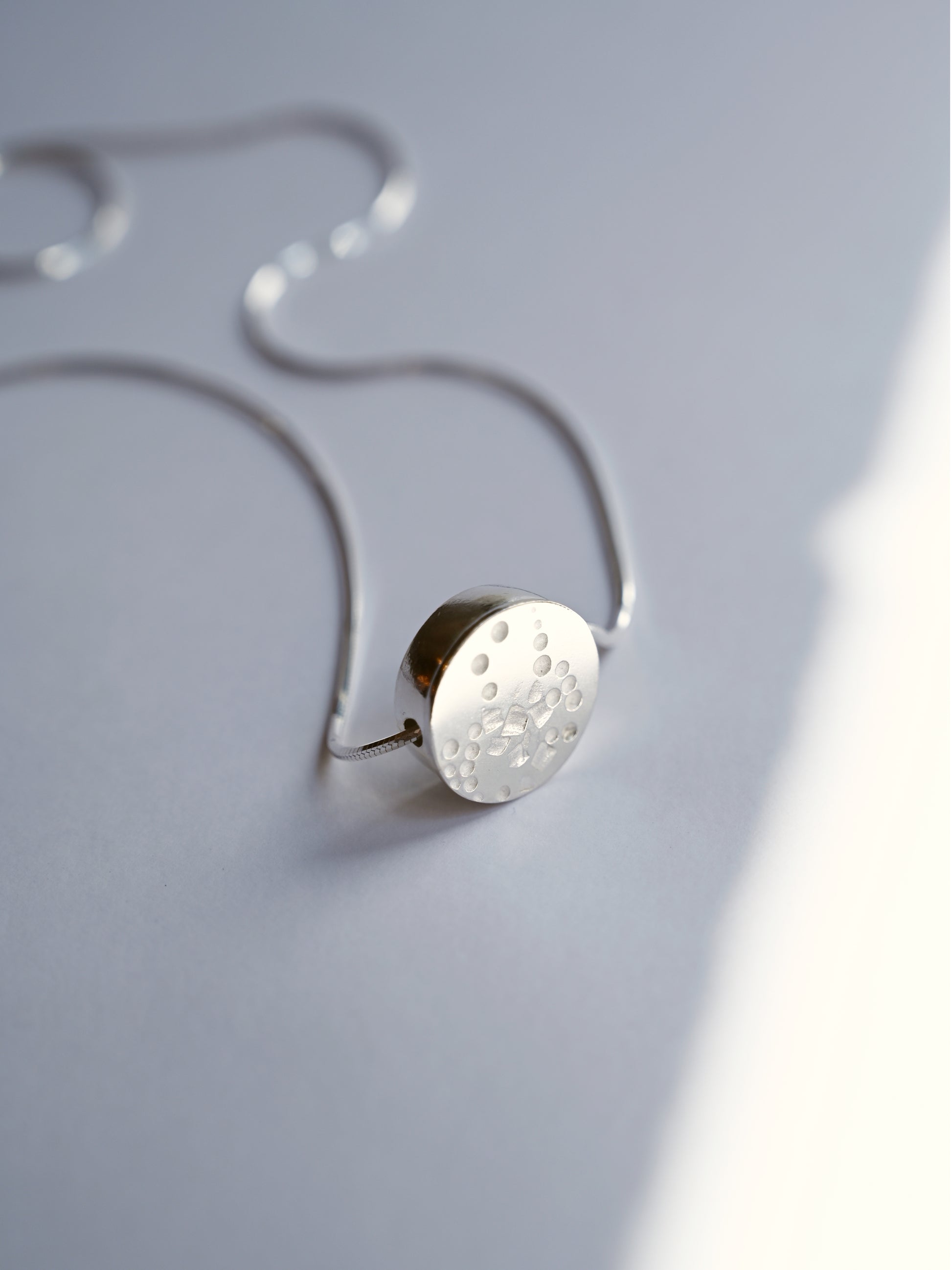 circle small necklace standing upright with a white background