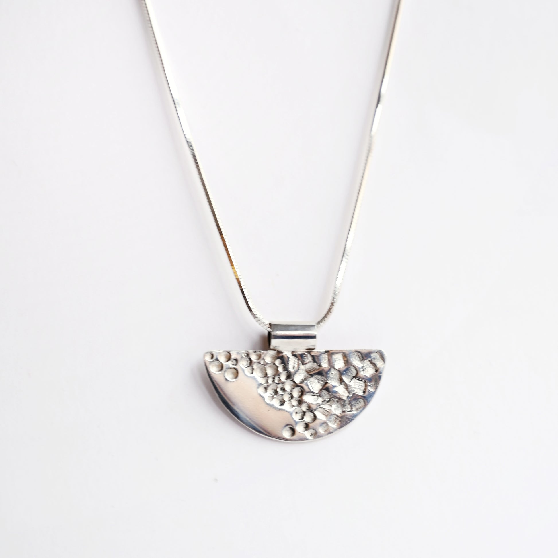 Silver half tube contrast pendant from front on white background