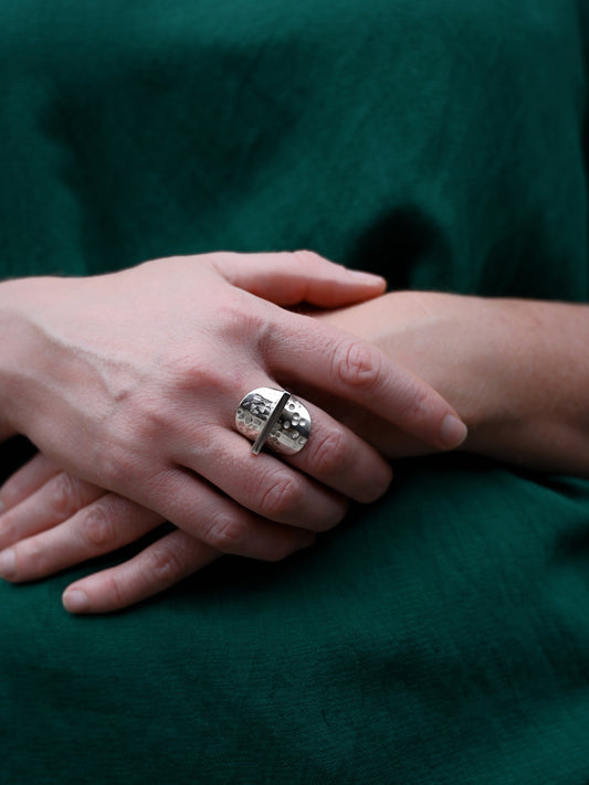 Front view of contrast ring modelled on hands with green shirt in background