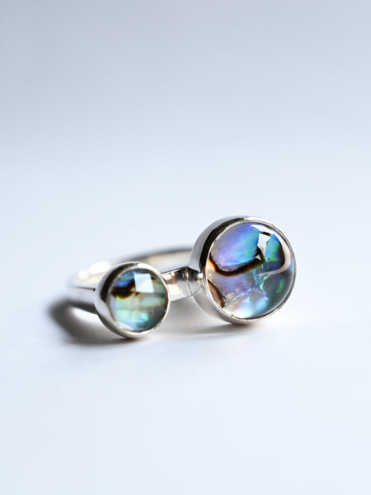Component silver ring with cabochon & faceted Abalone gemstones on white background
