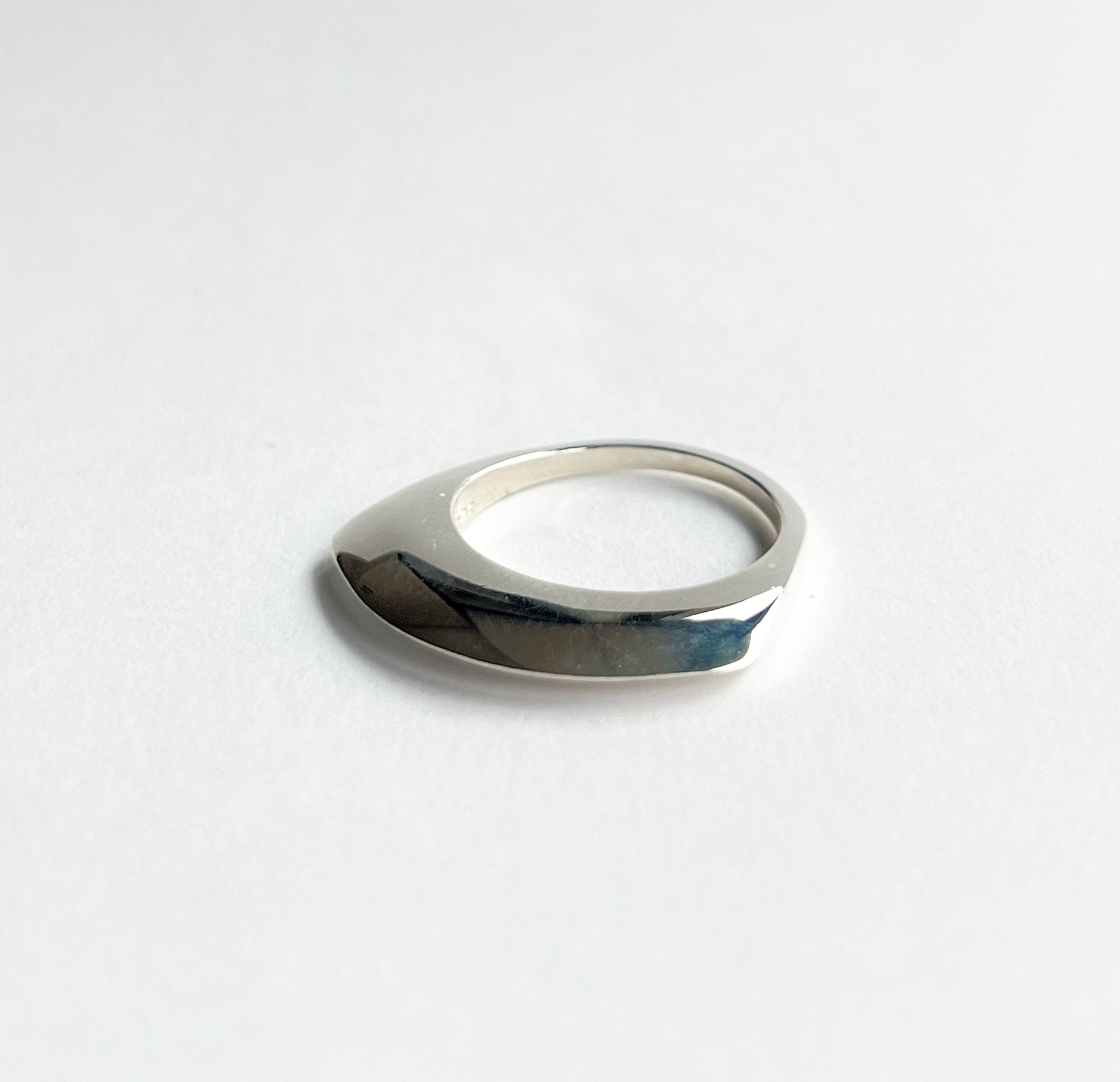 silver ring laying flat on a white background