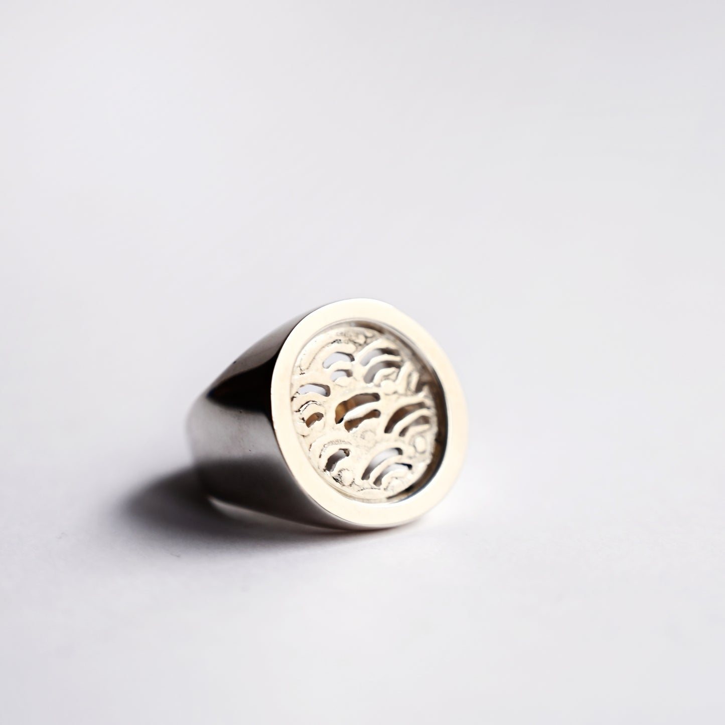 Node ring with a wave design cut out on a white background.