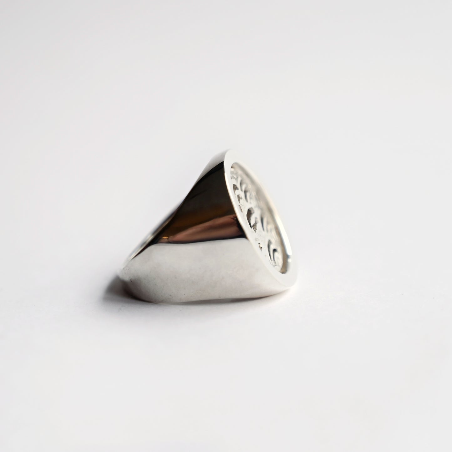 Silver node ring with wave design cut out on a white background
