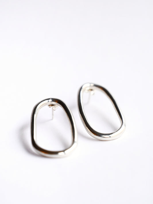 Small silver oval drop studs from front on white background