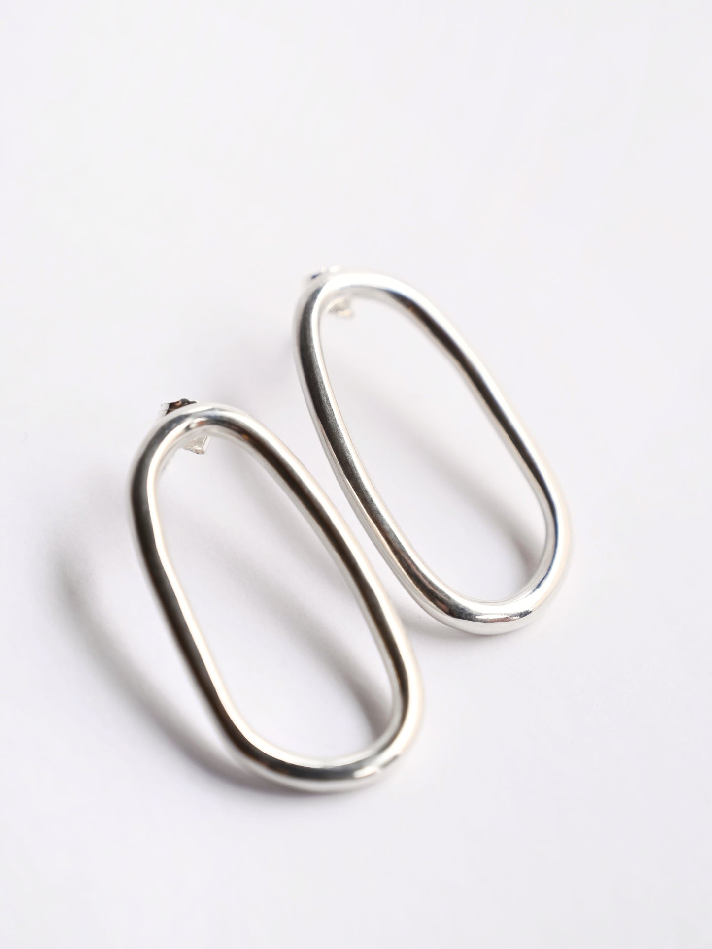 Large oval silver studs from top on white background