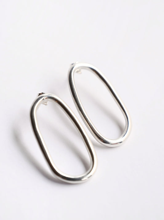 Large oval silver studs from top on white background